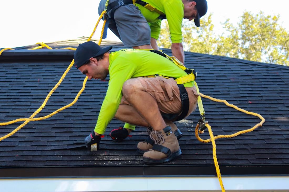 Two contractors working on the roof of a house