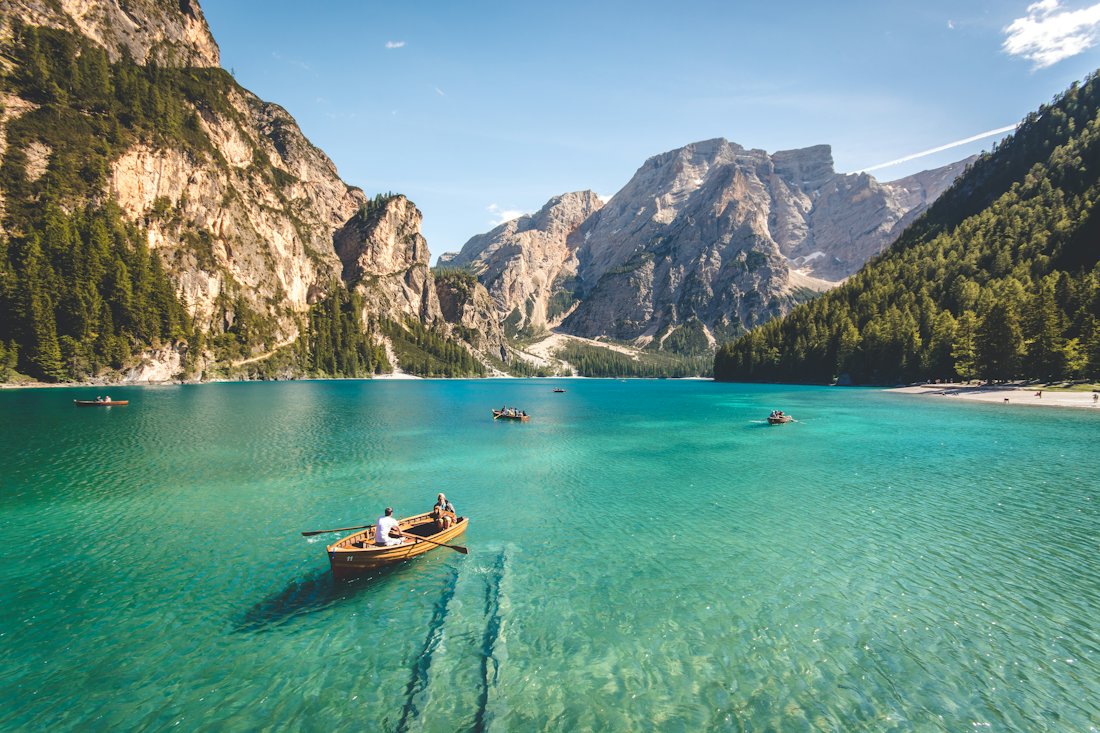 Alpine lake with boats below mountains